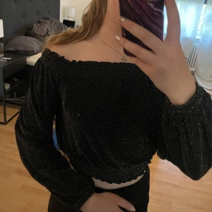Glittrig off-shoulder - Söt glittrig off shoulder topp. Väldigt stretchig med resår i ärmar och axlar.  Använd vid fåtal tillfällen. 