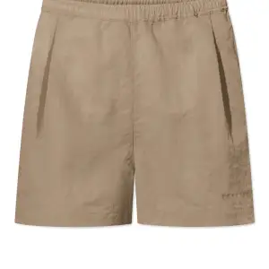 Shorts från Rue de Tokyo, modell Pauline Khaki. Helt ny, med prislapp kvar.  Storlek: M Material: 100% nylon Nypris: 930 SEK