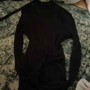 En svart ribbad tröja från Gina tricot. Strl Xs och knappt använd med inga skador. Med slits i armarna.