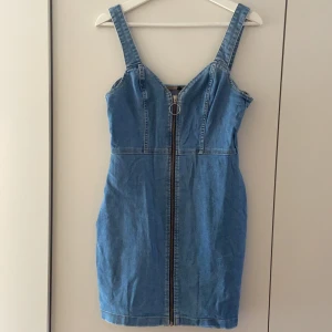 Kort jeansklänning - En kortare jeansklänning med dragkedja fram. I nyskick. 