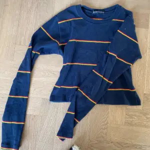 En långärmad tröja ifrån Brandy Melville, marin blå med gröna, röda och gula ränder 💕 tröjan är i bra skick ❣️