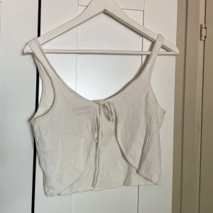 Somrig topp - Fin topp till sommaren från UO, stickad med knytning i ryggen. Använd men i bra skick! 