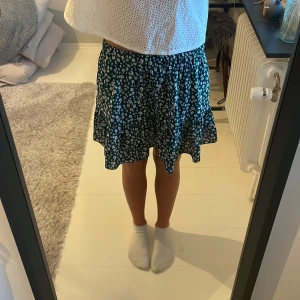 Blommig kjol - Mörkgrön kjol med vita blommor och volang