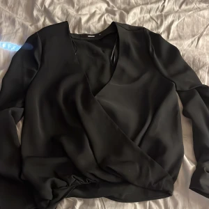 Blus  - Svart omlott blus från bikbok i storlek m. Aldrig använd💘