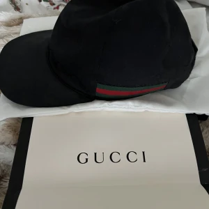Gucci Baseball Keps Svart - Säljer en svart Gucci keps sparsamt använd 9.5/10 skick Äkta solklart , original påse och fodral medföljer. Pris kan diskuteras vid snabb affär, endast frakt som köparen står för. Kontakta mig vid mer frågor och bilder. Byte intressant, inte andra kepsar