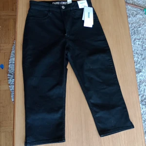 Längre shorts svarta - Shorten går lite över knät, är aldrig använda och lappen sitter kvar. Köparen betalar frakt 