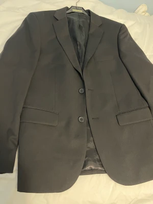 Kavaj dressman  - Säljer kavaj från dressman som jag växt ur. Använd en gång på skolavslutningen för 3 år sedan.  Nypriset idag ligger på ca 2000 för kavajen. 
