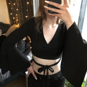 Topp med snören och utsvängda ärmar - Säljer den här gulliga toppen med uthängda ärmar och snören som man kan snyta runt midjan. Okej skick, ena sidan av snöret är tyvärr lite sönder, men inget jag skulle säga man tänker på när man har knutit ihop de. Säljer då jag inte använder längre.