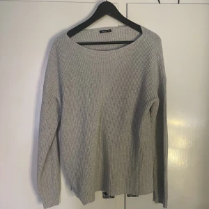 Stickad tröja  - Stickad tröja med slit på ena sidan och en dragkedja på andra.