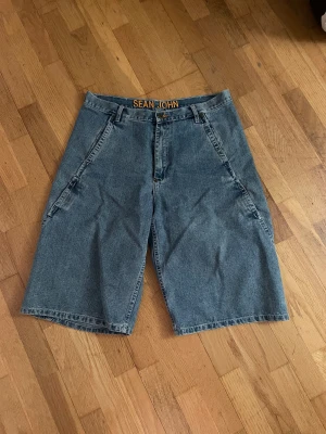 Jeans shorts  - Hej! Säljer ett par jeans shorts från märket Sean John. Köpt på stadsmissionen på Kungsholmen. Baggy och najs 