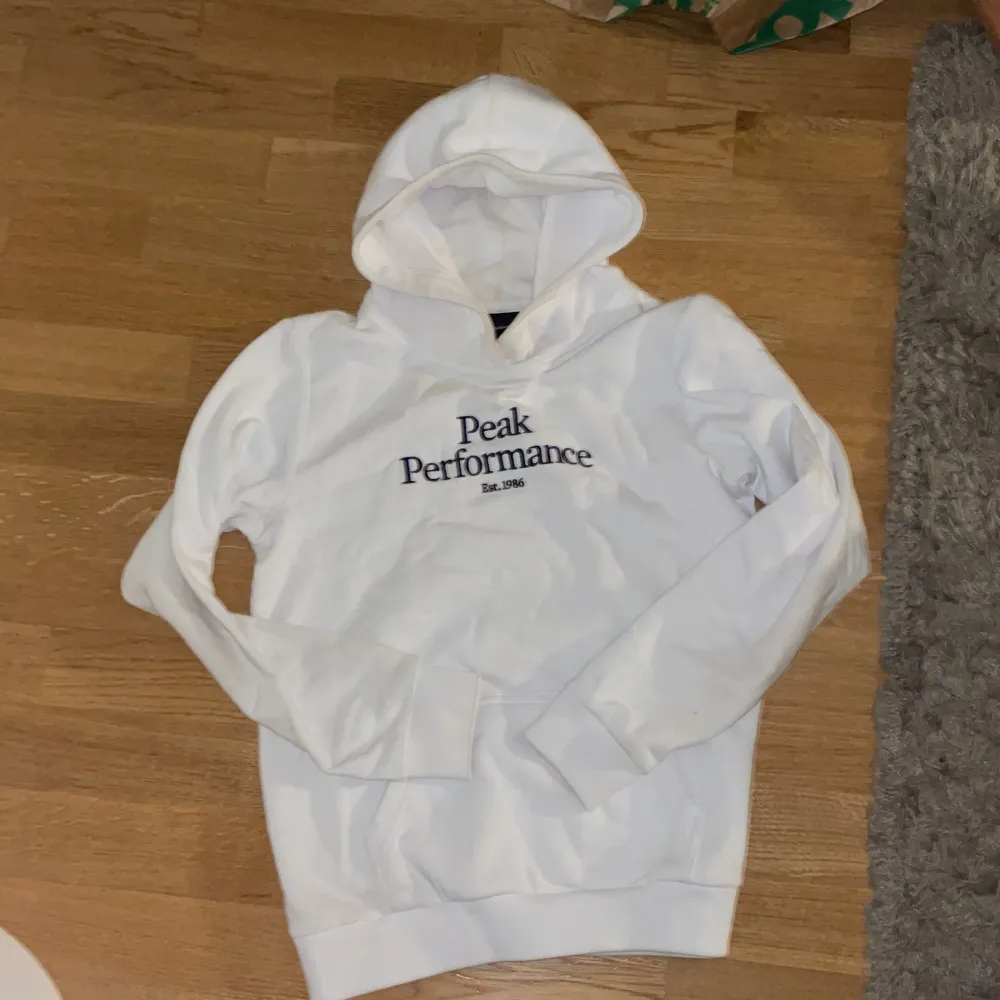 En jättefin vit Peak Performance hoodie. Köpt för 599kr säljer för 250kr. Storlek 160-165cm. . Hoodies.