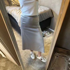 Grå/silvrig kjol! - Högmidjad grå/silvrig satin kjol, från nakd i storlek 36! I bra skick förutom några få revor i tyget (se bild 3), inget som syns på långt håll!