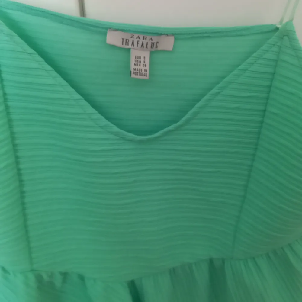 Green, short top with a zipper on the other side. . Toppar.