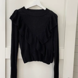 Tröja med volang - Svart söt stickad tröja med volang