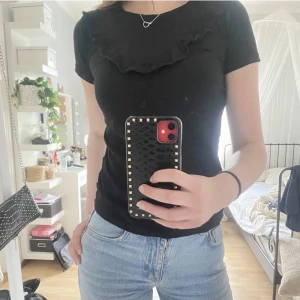 T-shirt - Säljer denna snygga t-shirt med volang på bröstet. Använt fåtal gånger så den är i fint skick. Tröjan är i storlek 146/157 men passar en xs/s med