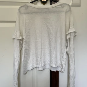 Tröja med volanger - Söt tröja med lite volanger som detaljer på ärmarna. Jättefin, lite genomskinlig men har man nude under så löser det sig, använder inte längre.