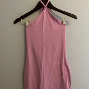 Kort rosa halterneck klänning. Aldrig använd och med prislappen kvar. 