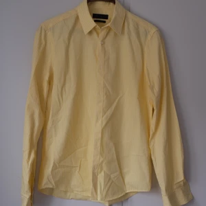 Randig skjorta - Gul randig skjorta från Riley. Mycket fint skick. Jag har haft den öppen med en vit tröja under :))