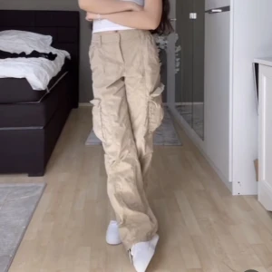 Lågmidjade cargobyxor - Säljer jättesnygga beiga lågmidjade cargobyxor, är jätteskönt tyg och stretchiga i midjan, populära och slutsålda, väldigt y2k stil