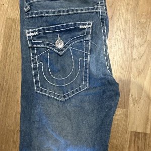 True Religion byxor  - Detta är ett par feta joey super t trueys ja köpte för ett tag sen. Byxorna saknar en knapp på en av bakfickorna. Obs inga returneringar  Midja:43cm diametern    Längd:98cm Innerben:73cm 