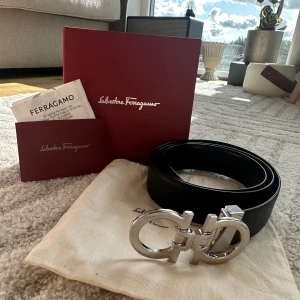 Ferragamo bälte - Säljer mitt helt nya ferragamo bälte som är helt oanvänt. Box och kvitto ingår såklart. Det går att ändra sida på bältet så det går att ha den som svart och marinblå. Butiks priset ligger på 550€ vilket motsvarar. 6500kr