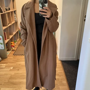 Ullkappa - Kamelfärgad kappa i ullblandning med fint fall. Så fin men känns lite lång på mig som är 162 cm. Mycket sparsamt använd, inget att anmärka i skick.  