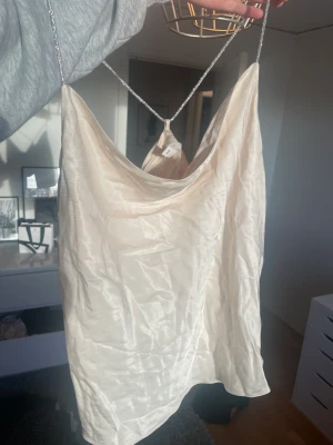 Satin linne med öppen rygg - Festtopp med glittriga band och öppen rygg. Aldrig använd då den helt enkelt inte var min stil. Den är i strl M men är lite mindre i storleken, särskilt över bysten. Från H&M. Köparen står för frakten😊