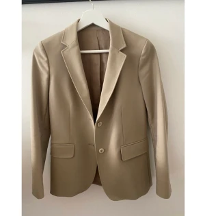 Beige kavaj Arket - Jättefin beige kavaj från arket i storlek 34. Superfint skick. Säljer pga kommer inte till användning. 