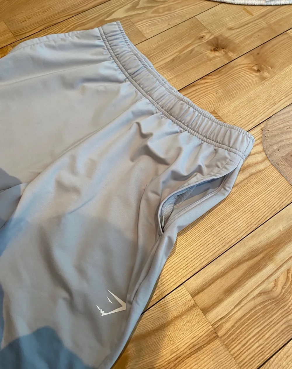 Gymshark träningsbyxor i strl S, superfint skick. Som ny. Endast använd fåtal gånger. Dragkedja vid fickorna och snören vid insidan av midjan.. Jeans & Byxor.