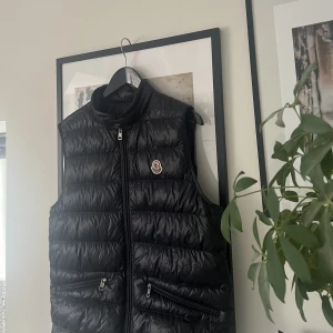 Moncler gui väst - Säljer nu min moncler gui väst, använt Max 5 gånger, har dock ett litet hål längst ner, skick 9/10 då hålet är de ända som drar ner skicket, köpte från moncler hemsida och har orderbekräftelsen därifrån samt en påse, bytesförslag tas positivt! Nypris 6500