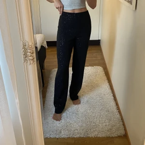 Byxa - Glittriga svarta byxor i mjukt material, från Nelly i storlek M. Jag är 1,77