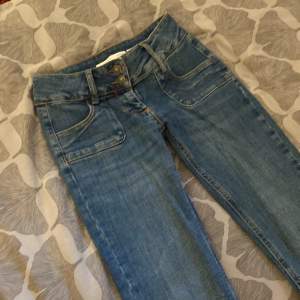 Jättefina lågmidjade jeans som jag säljer då jag har ett par liknande💕Fina detaljer såsom fickor därfram och flera knappar. De är flared där nere men sitter tajt på låren De är 34 cm rakt över i midjan och 83 cm i innerbenslängd❤️