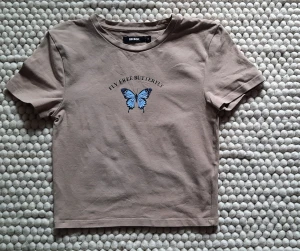 Beige T-shirt från Bik Bok - Beige T-shirt från Bik Bok.  Väldigt lite använd  92% Bomull  8 % Elastan  Längd 34 cm