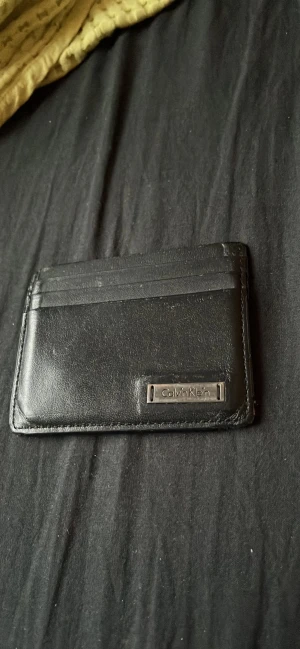 Calvin Klein Korthållare - Säljer min gamla Calvin Klein korthållare. Den funkar bra som den ska. Inga repor eller hål! Priset går att diskuteras.