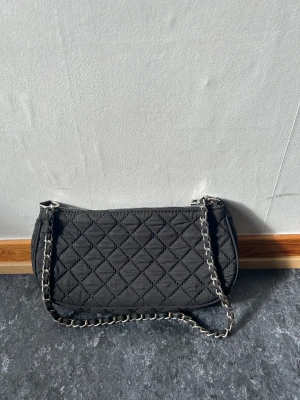 Svart axelväska - En svart axelväska från ginatricot 