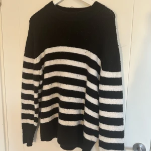 Stickad tröja  - Vit och svart randig stickad tröja från H&M. Perfekt för hösten! 