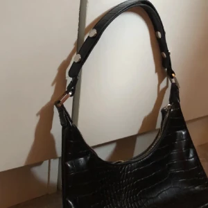 Handväska  - Svart handväska i nyskick, ormskinnsmönster 