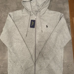 Ralph Lauren Zip Hoodie Helt Ny - Helt ny Ralph lauren zip hoodie med etikett kvar. Den är i storlek M. Fick den i present men den passar inte mig.
