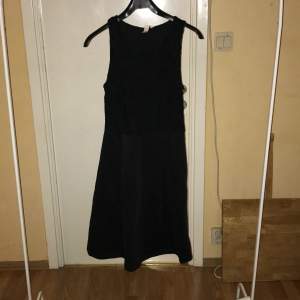 Svart klänning med spetsdetaljer upptill längd 98 cm