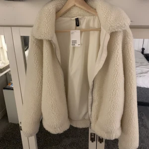 Créme vit Teddy jacka - Hej,säljer denna jättefina Teddy jackan som är oandvänd med lappen kvar. Den är i nyskick och säljer för att den ej passar! Nypris är 400kr jag säljer för 200kr!🩷