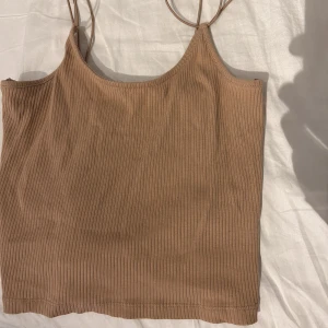 Basic linne - Säljer detta beiga ribbade basic linnet. Perfekt unde färg att ha som ett bad linne antingen bara som de är eller under en annan tröja. Använd endast ett fåtal gånger.