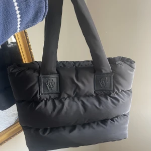 Vadderad totebag Carin Wester - Jättefin mjuk och rymlig svart vadderad totebag från Carin Wester. Tre innerfickor varav en med dragkedja. Mått: bredd 50 cm, höjd 36 cm och djup 14 cm. Knappt använd. Nypris 599 kr.😍