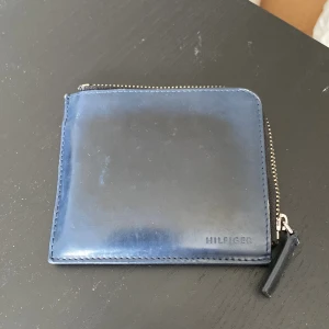 Tommy Hilfiger zip wallet  - Tjena  Säljer denna fina läder plånboken från Tommy Hilfiger  Är i jätte bra skick och blixtlåset funkar fortfarande  Vid frågor eller intresse skriv 