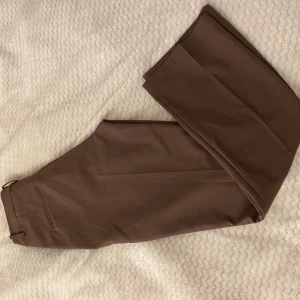 Bruna kostymbyxor  - Jättefina bruna kostymbyxor från bikbok! Raka i benen. Kommer inte till användning. Nyskick.