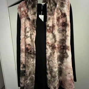 Väst med luva  - Mysig fuskpäls väst med luva. Använt sparsamt 