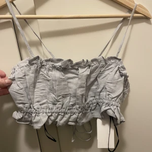 Croptop linne - Ljusblå crop top i linnematerial snörning bak. Stl xs. Helt ny, prislapp kvar. 