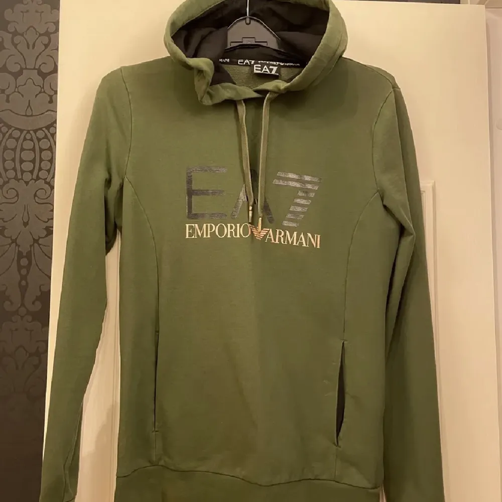 Säljer nu min EA7 Armani hoodie för 400 kr. Äkta och köpt på JD för ungefär 1000 kr. Jag har knappt använt den men ena ploppen på snöret har gått bort men inget som märks. Storleken är S.. Hoodies.