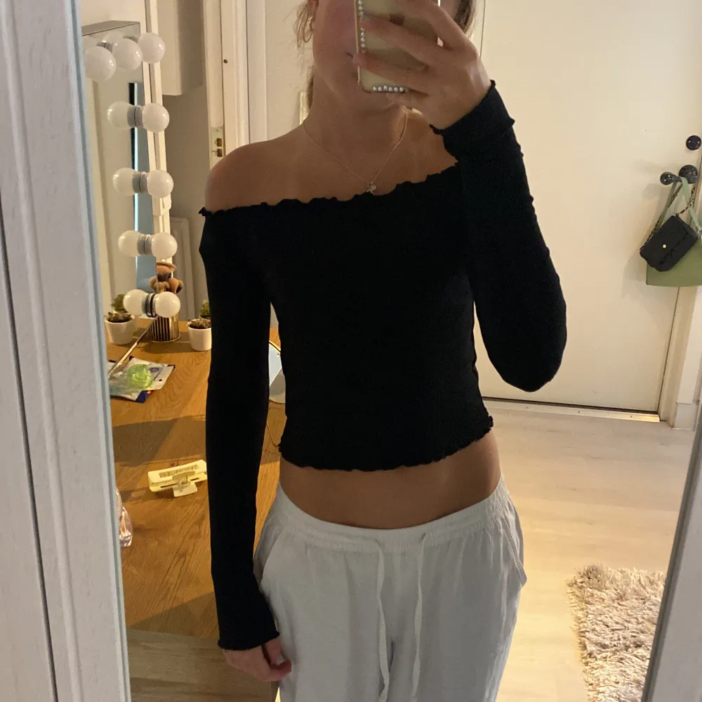 Svart ribbad tröja i strechigt material. Off shoulder, volang vid nacke, ärmar och midja! Nyskick!💕. Toppar.