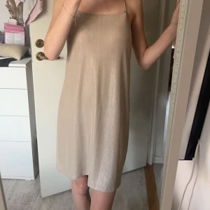 Beige klänning zara  - Så fin klänning från zara i beige färg med lite glitter i🩷 den är inte glittrig men är lite glansig i tyget. I mycket fint skick! Jag är 167 cm 