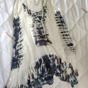 Ärmlös tunika Batikfärgad - Ärmlös tunn mjuk vit och blå batikfärgad bommullstunika. KappAhl. Ca 70 cm fram och ca 75 cm bak. 